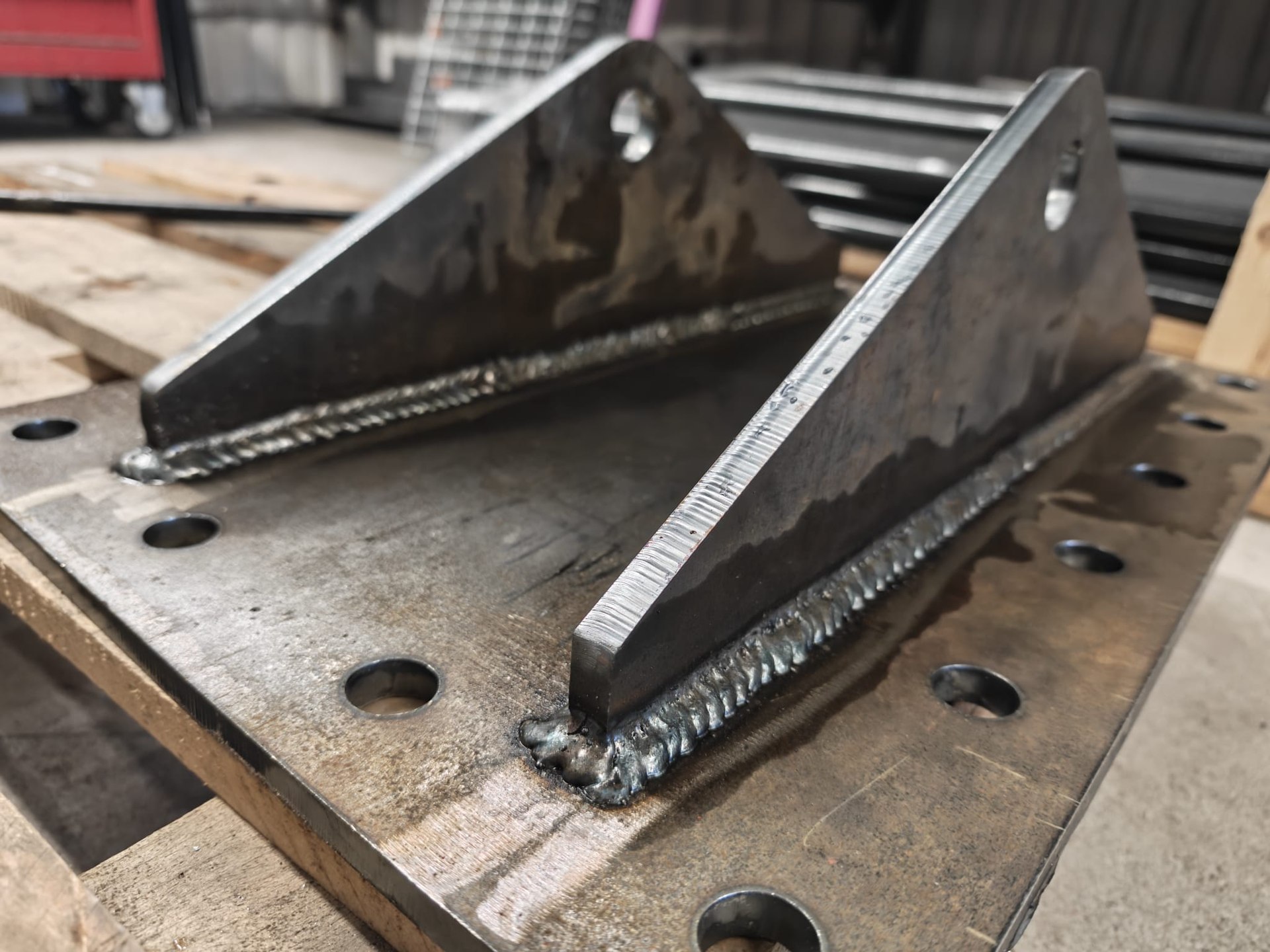 Welded stiffeners and a connection plate on a workbench.