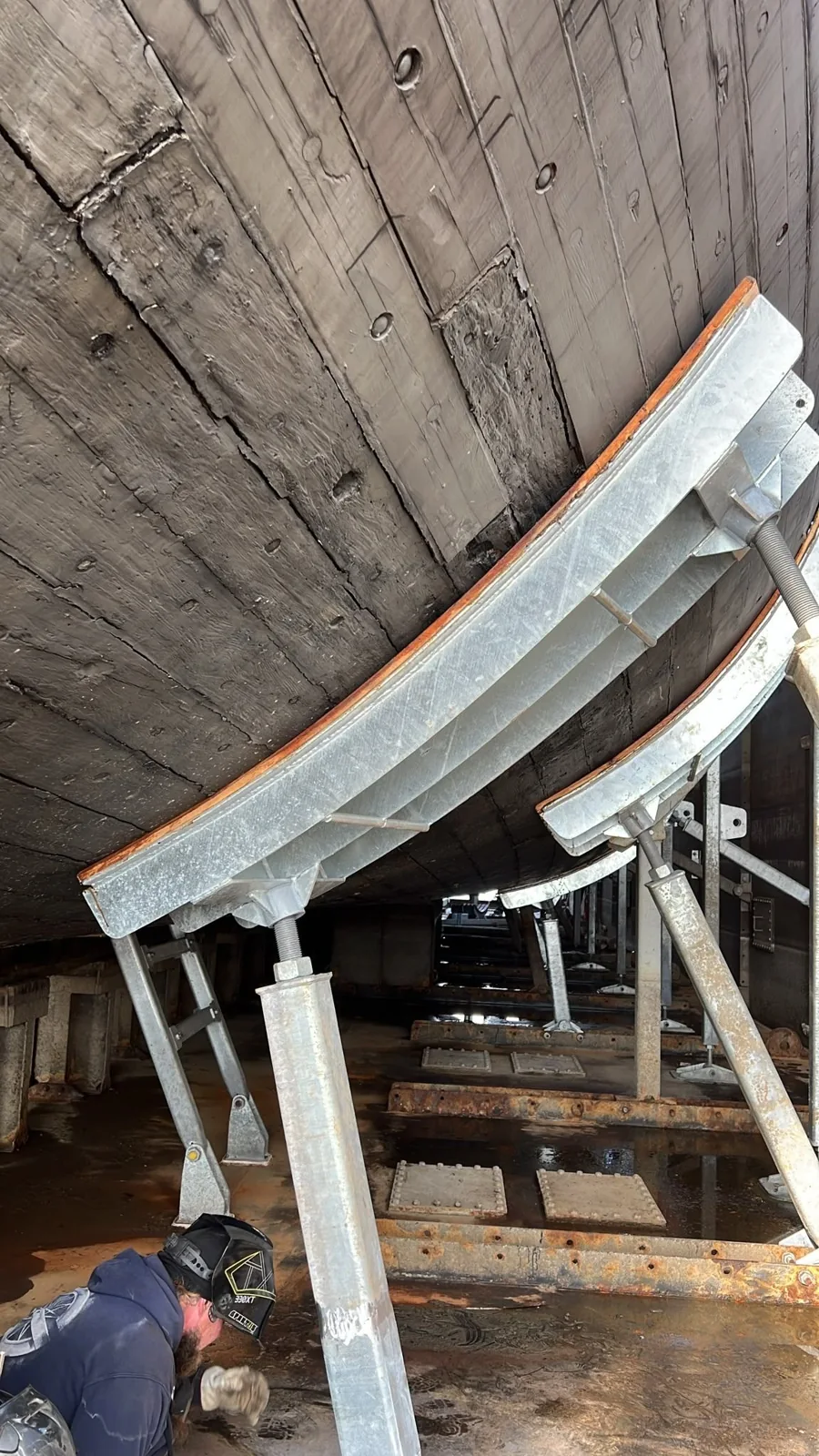 A curved steel support fitted beneath the wooden hull.