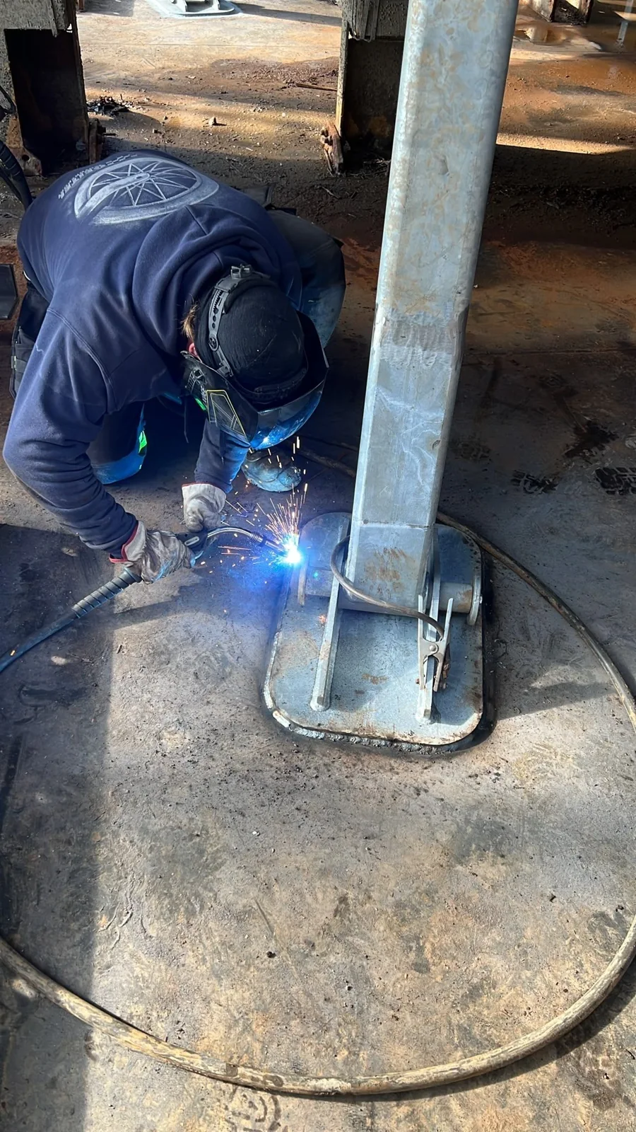 An installer welding the base of a steel support for Sigyn.