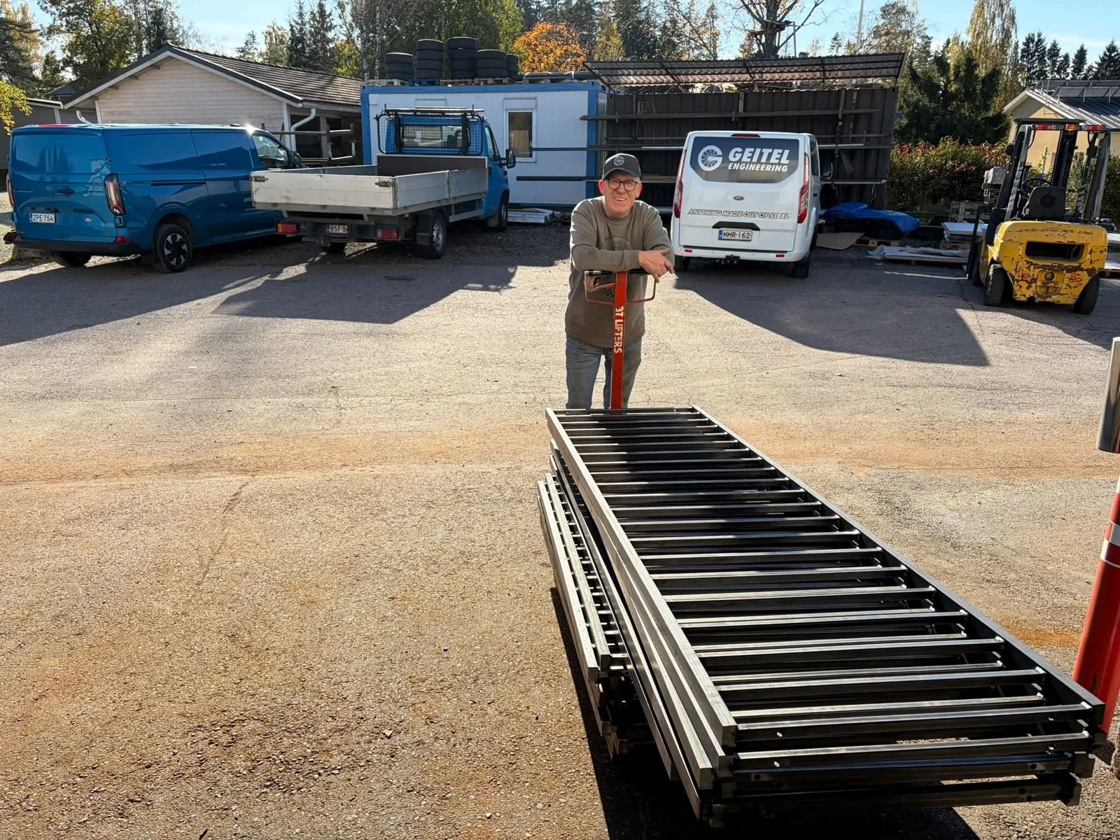 Nicholas (Nick) Geitel in the workshop yard, with fabricated railing panels in front of him.