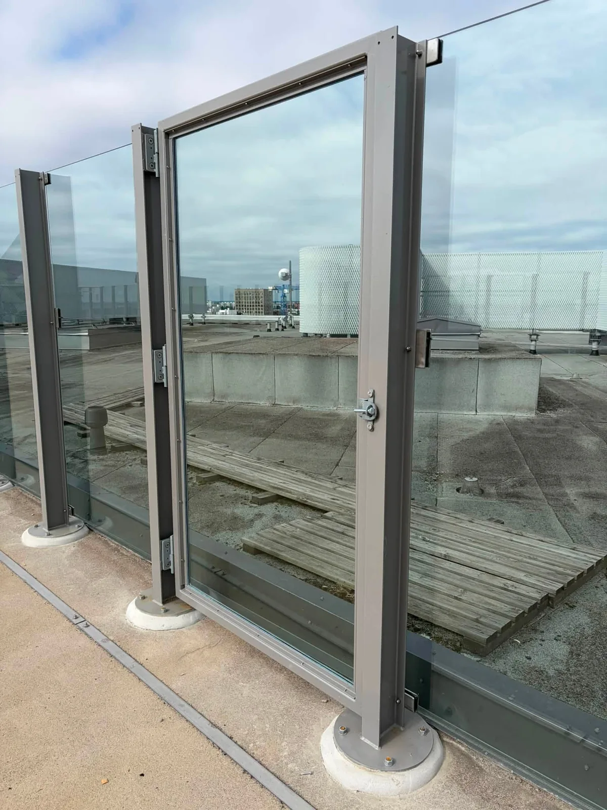 A glass railing and metal gate on the rooftop.