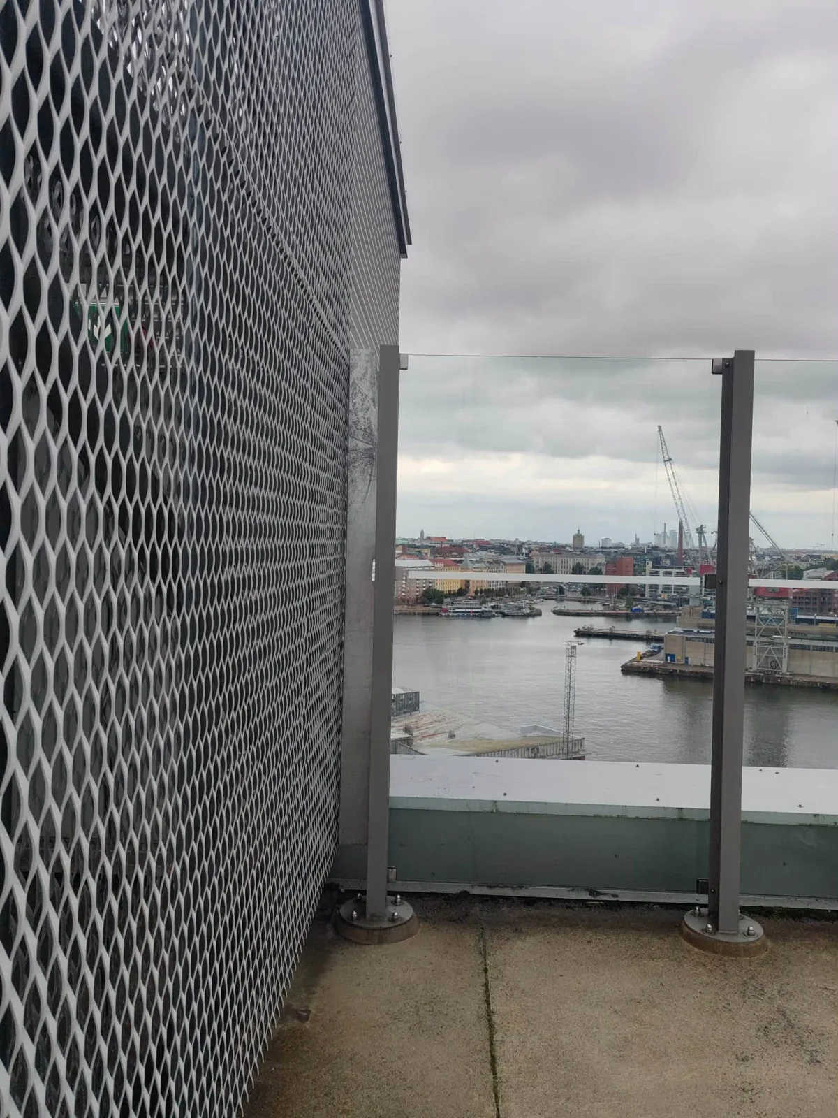 The junction between a mesh structure and a glass railing.