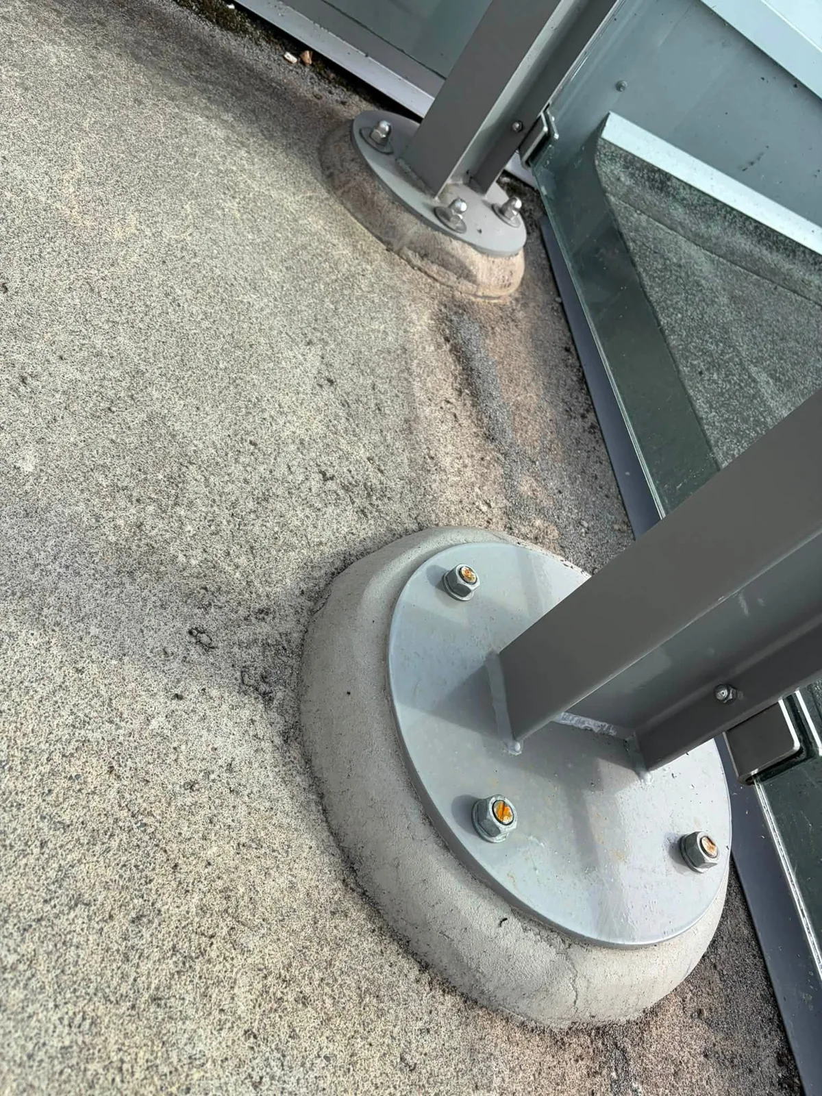The base and fixing of a railing post on the rooftop.